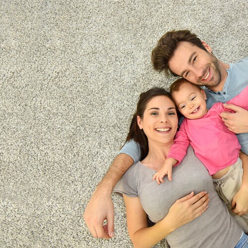 Happy couple laying on carpet floor | Carpet And Floors For Less